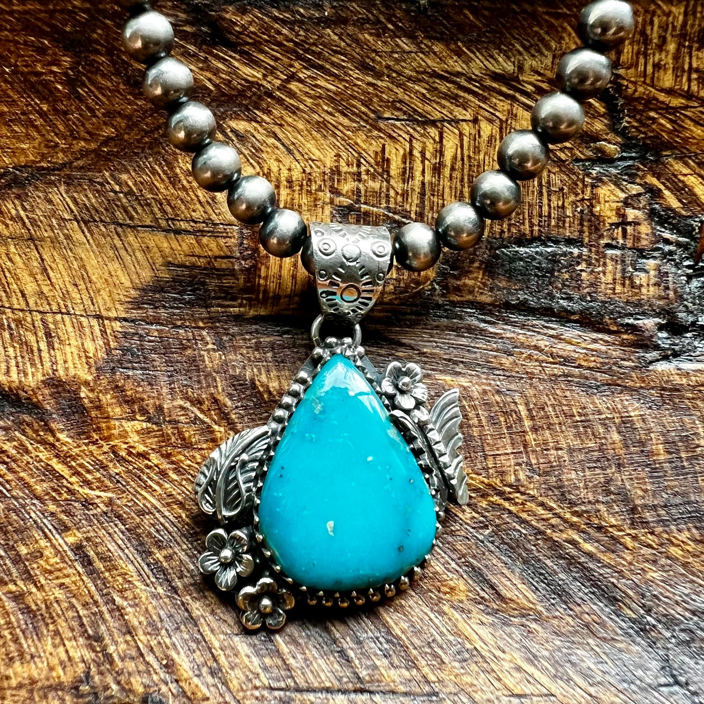 Kingman Turquoise Teardrop Pendant – Sterling Silver Floral Detail