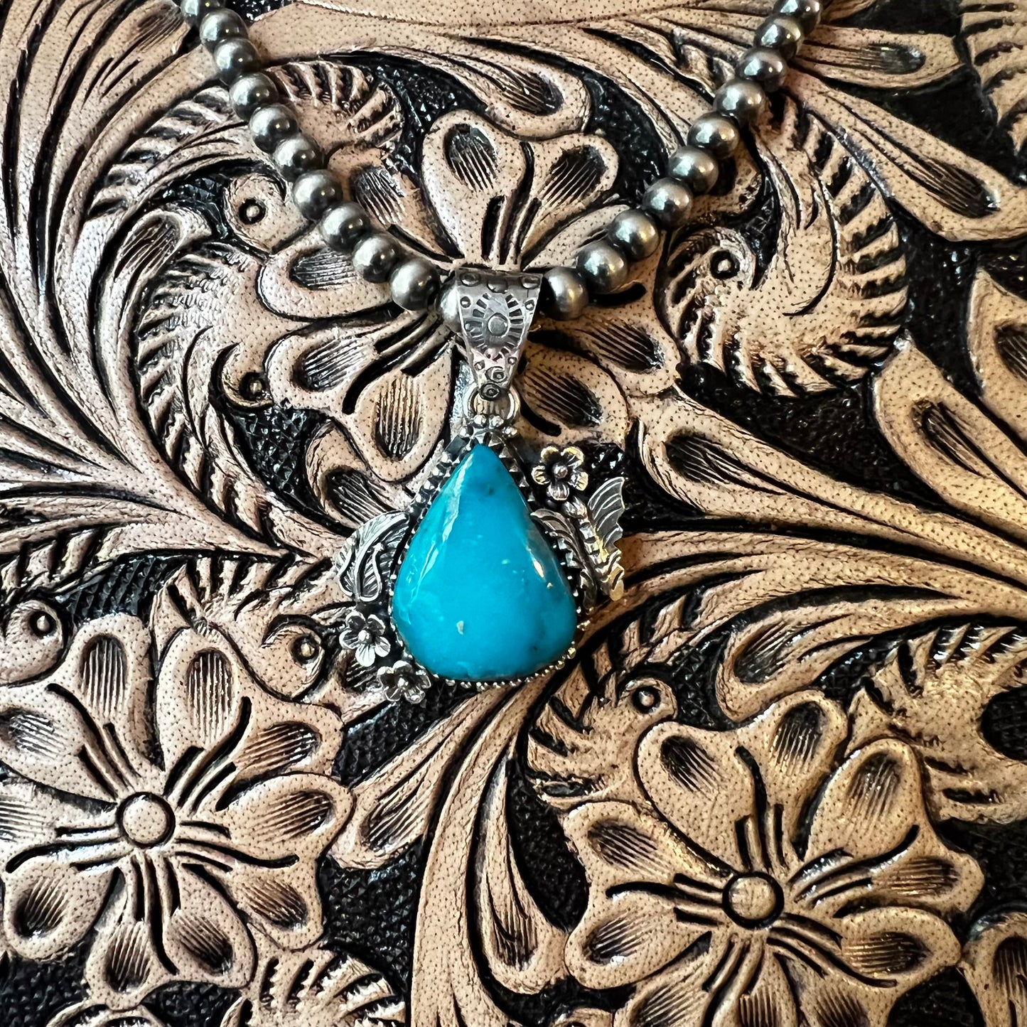 Kingman Turquoise Teardrop Pendant – Sterling Silver Floral Detail