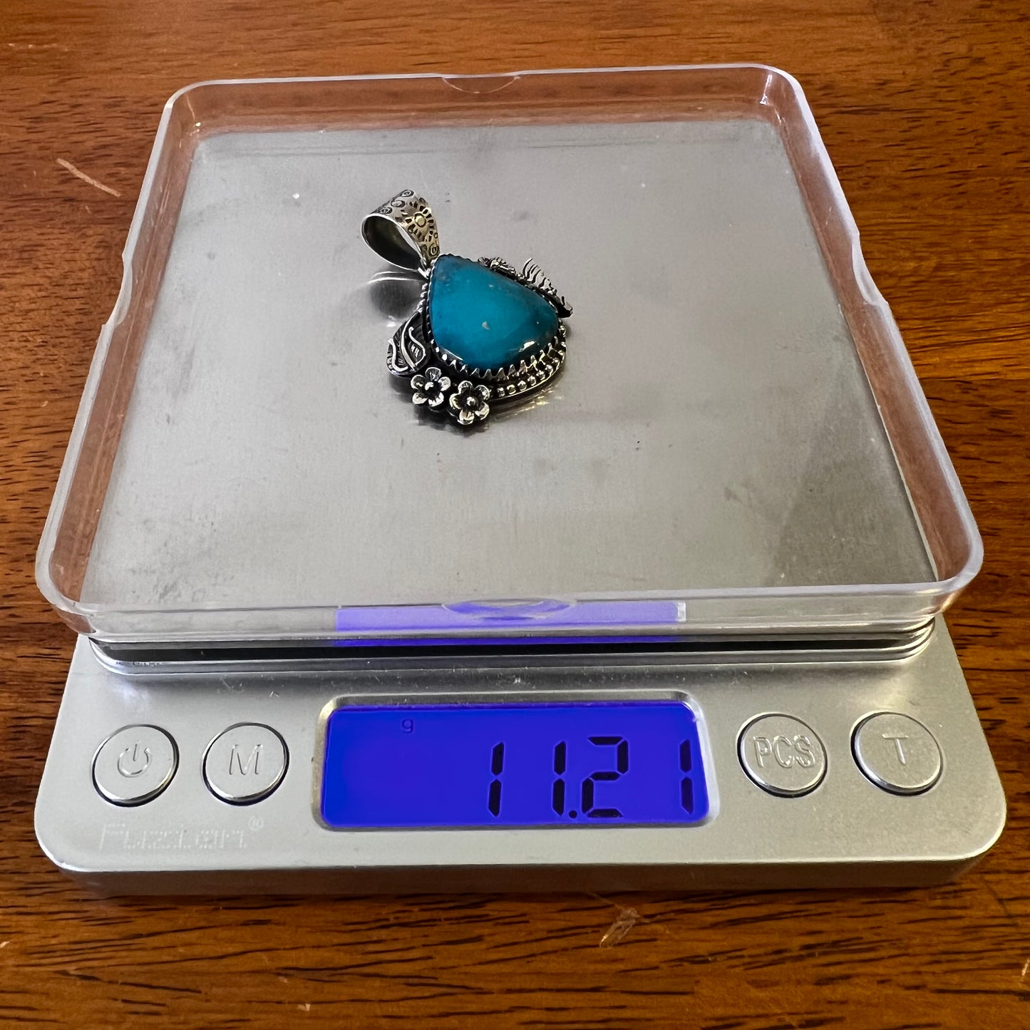 Kingman Turquoise Teardrop Pendant – Sterling Silver Floral Detail